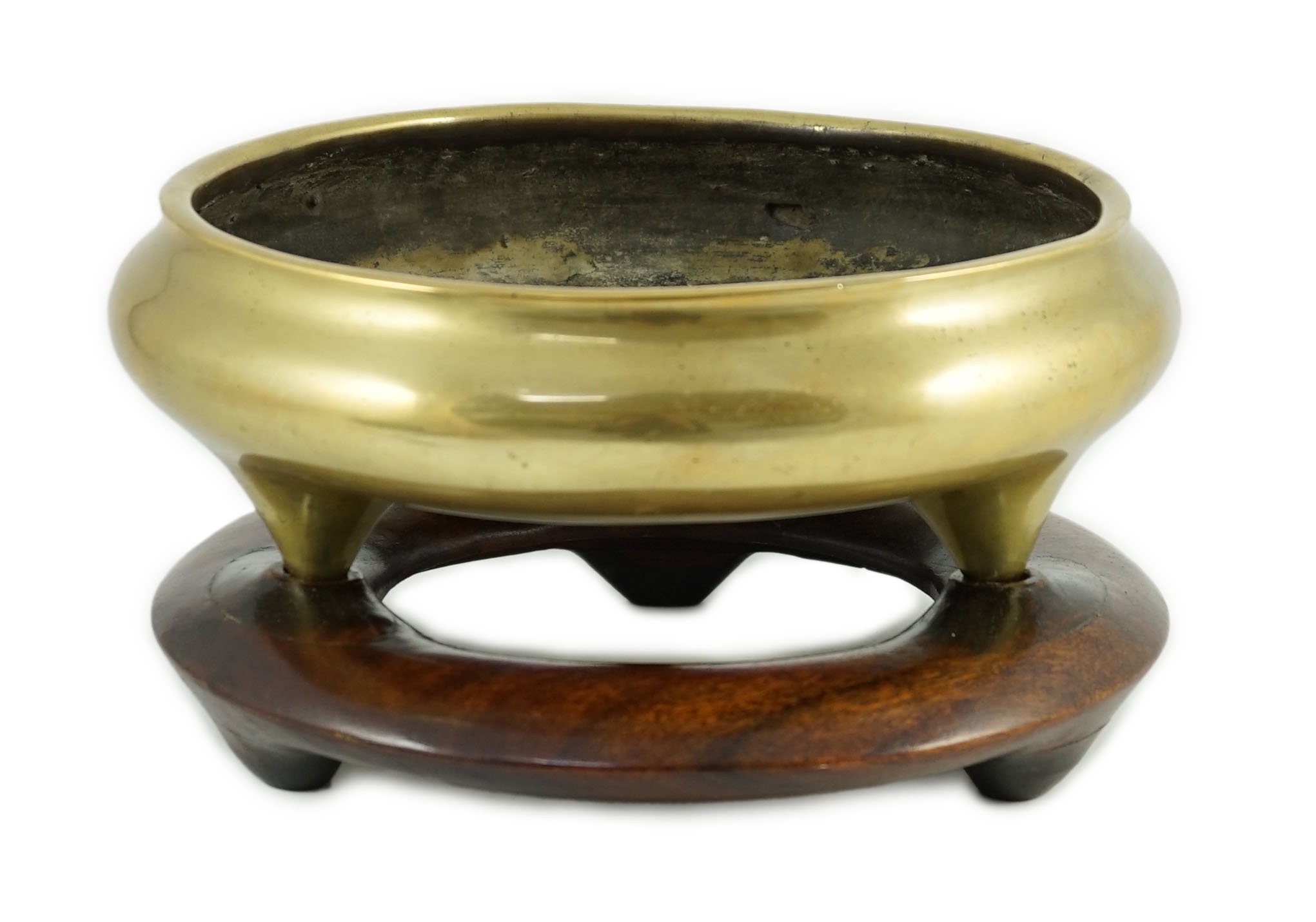 A large Chinese polished bronze tripod censer, 19th century, private four character seal mark, 29.5 cm diameter, Disc shaped rosewood stand